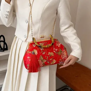 Elegant red floral shell bag with bamboo handle, gold chain, and red tassel detail