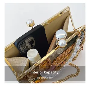 Internal capacity of sequined evening clutch showing phone and cosmetics with chain strap