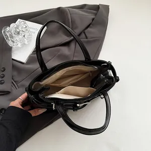 Borsa sottobraccio nera lucida stile moto con ampio interno e fodera beige