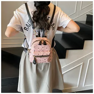 Detail eines rosa plissierten Mini-Rucksacks mit schwarzen Schleifen und Reißverschluss