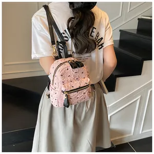 Detail eines rosa Plissee-Mini-Rucksacks mit schwarzen Schleifen-Prints und Gold-Hardware