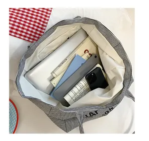 Interior view of striped canvas tote showing spacious compartment and laptop storage