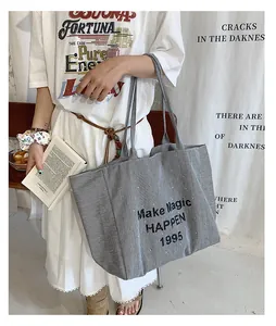 Detail of canvas tote bag with black and white stripes and Make Magic HAPPEN print