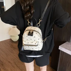 Schicker beiger Mini-Rucksack mit schwarzen Schleifen-Prints und Steppmuster für Alltag