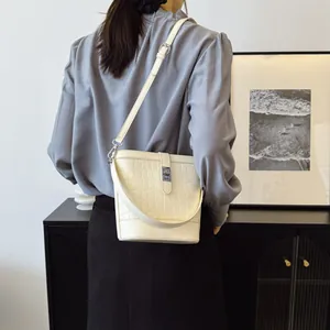 Minimalistische beige Beuteltasche mit Krokoprägung und verstellbarem Schultergurt Damen