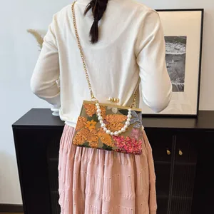 Sequin shell crossbody bag with floral embroidery and elegant pearl handle strap