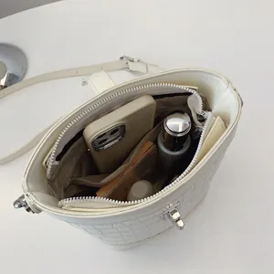 Weiße Eimer-Handtasche in Krokodilleder-Optik mit silbernem Verschluss und viel Platz