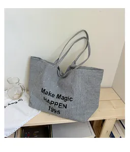 Detail of large canvas tote bag with black and white stripes and Make Magic HAPPEN print