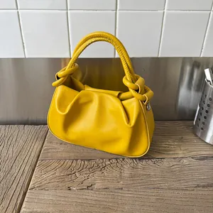 Modern bright yellow cloud-shaped handbag with knotted handle and pleated leather design