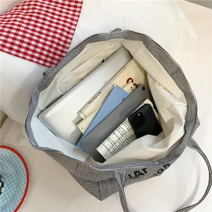 Large capacity striped canvas tote bag with interior pockets and secure snap closure