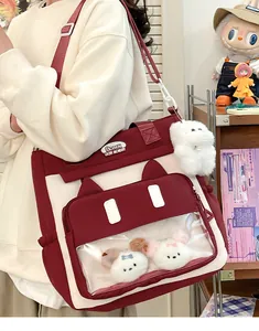 Close-up of cat-eared ita bag with transparent PVC window and plush kitty charms