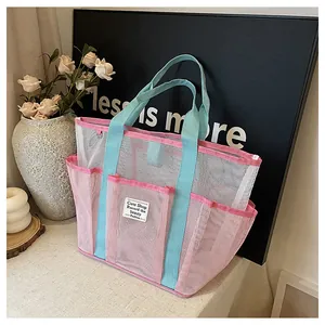 Mesh storage bag detail with pink and blue panels and multiple side pockets for beach