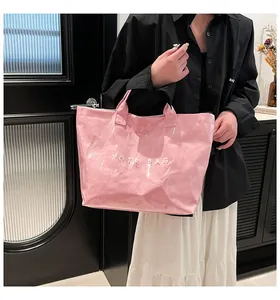Sac fourre-tout rose en Tyvek PVC avec texte blanc porté par une femme en style décontracté
