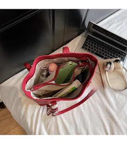 Spacious red tote bag interior with multiple compartments and silk scarf detail