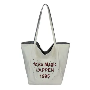 Minimalist cream canvas tote bag with red Make Magic lettering and striped lining