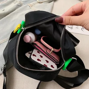 Vertical oxford crossbody bag in black with colorful charms and organized interior storage