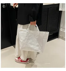 Gros plan sur le texte TOTE BAG embossé d'un sac cabas blanc en papier Tyvek et design