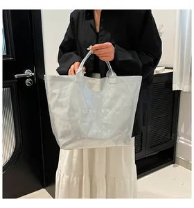 Détail du sac cabas en papier DuPont argenté avec texture plissée et texte Tote Bag