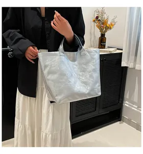 Détail du sac cabas argenté en Tyvek avec texture froissée et logo TOTE BAG imprimé
