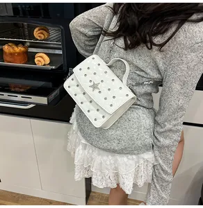 Détail du mini sac blanc matelassé avec clous argentés et étoile décorative