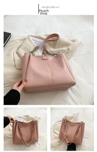 Detail of peach pink PU leather tote bag with vertical stitching and metal chain strap