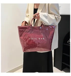 Vue détaillée de la texture PVC rouge vin brillant et du lettrage blanc du sac cabas