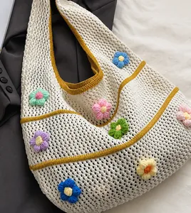 Detaillierte Nahaufnahme der Strick-Tasche mit bunten 3D-Häkelblumen-Verzierungen