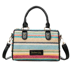 Colorful woven stripe bucket bag with black leather handles and adjustable shoulder strap