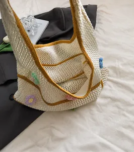 Nahaufnahme der Häkeltasche mit bunten 3D-Blumenakzenten und gelbem Rand-Detail