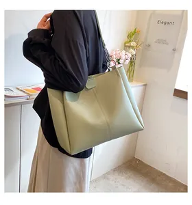 Detail of light green PU leather tote bag with vertical stitching and metal ring strap