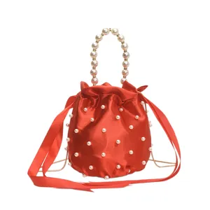 Elegante borsa a secchiello in raso rosso con perle e manico di perle raffinato