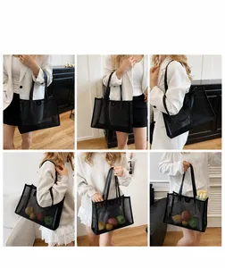 Detalle del bolso tote de malla negra con letras blancas y gran capacidad interior