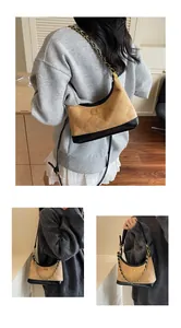 Détail du sac patchwork en daim camel et cuir noir avec motif matelassé et chaîne dorée
