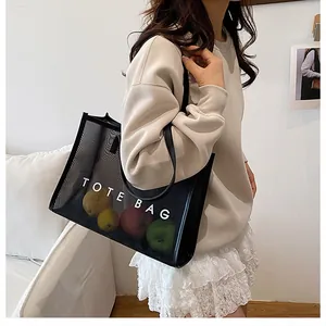 Vista detallada del bolso tote de malla negra que muestra gran capacidad y diseño