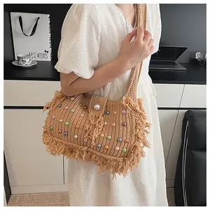 Detailed macro view of multi-colored pearls and fringe on a woven summer tote bag