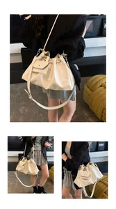 Detail view of cream white bucket bag with drawstring closure and matching mini pouch