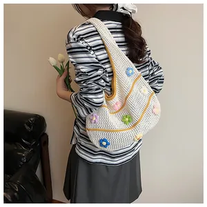 Détails de fleurs tricotées et motifs ajourés sur un grand sac fourre-tout en maille