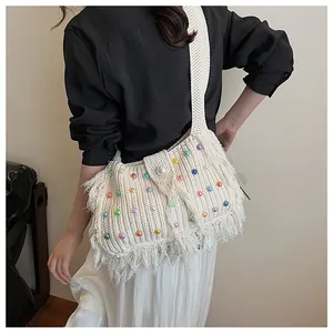 Detail of white crochet tote bag with colorful beads, fringe edges and pearl closure