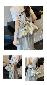 Detail view of silver drawstring bucket bag with textured metallic finish and crossbody strap