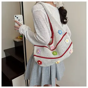 Détail du sac à bandoulière au crochet blanc avec fleurs 3D colorées et bordure rouge