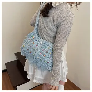 Detail of light blue crochet shoulder bag with colorful beads and pearl closure