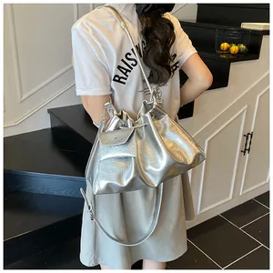 Detailed view of silver metallic bucket bag with drawstring closure and mini coin purse
