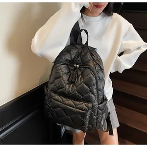 Detail of black quilted puffer backpack showing spacious front pocket and soft texture