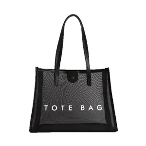 Bolso tote grande de malla negra con texto TOTE BAG y asas de cuero en fondo blanco
