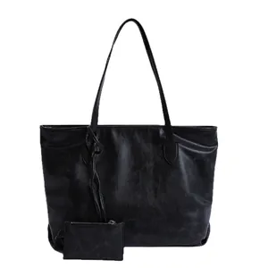 Minimalist black PU leather tote bag with a small matching pouch on a white background