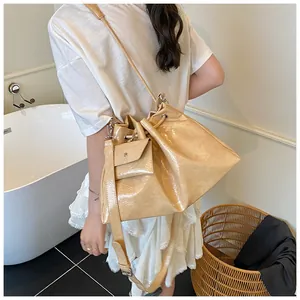 Detail of beige drawstring bucket bag with pleated texture and mini coin purse charm