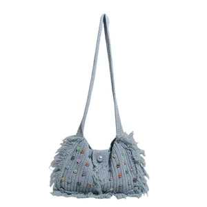 Light blue knit tote bag with colorful pearls and fringe trim for summer beach travel
