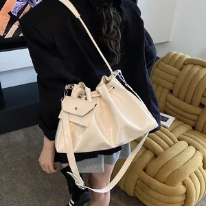 Chic off-white drawstring cloud bucket bag with matching mini pouch on a crossbody strap