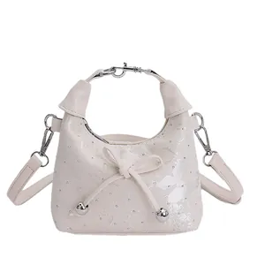 Sac seau blanc cassé élégant avec texture pailletée, nœud et poignée anneau métal