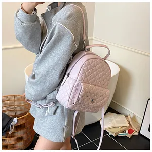 Détail d'un sac à dos matelassé rose avec strass brillants et fermoir rotatif en métal